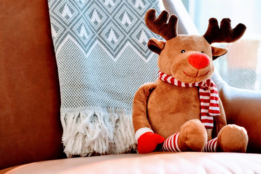 Reindeer plushie propped up on a couch.