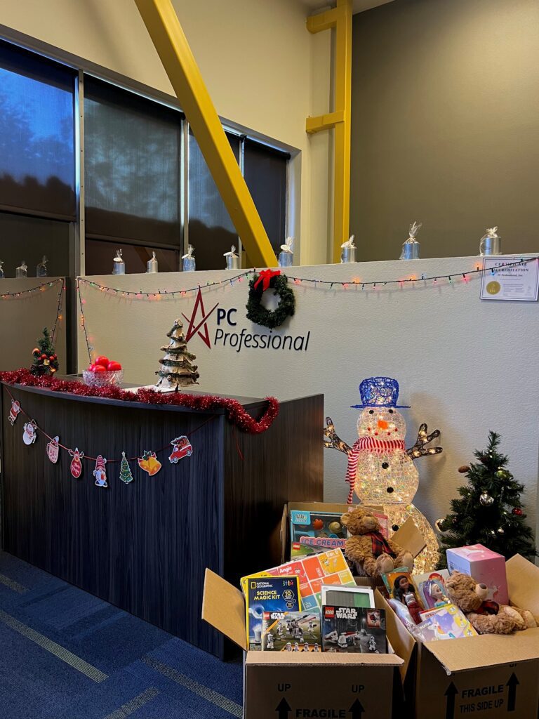 3 Boxes filled with toys, set up in front of a snowman and cheery office decor.