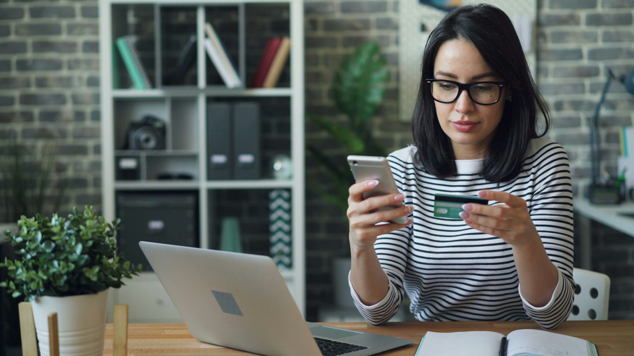 A woman entering payment information while using her devices.