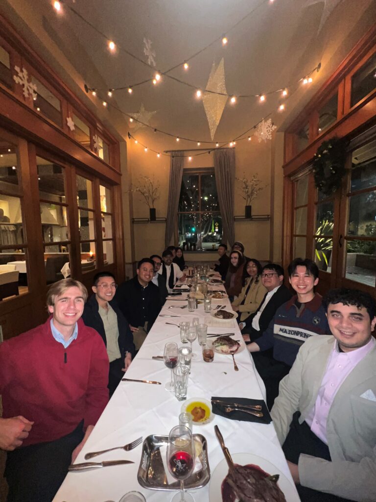 A majority of the PC Professional engineers sitting at a long dinner table.